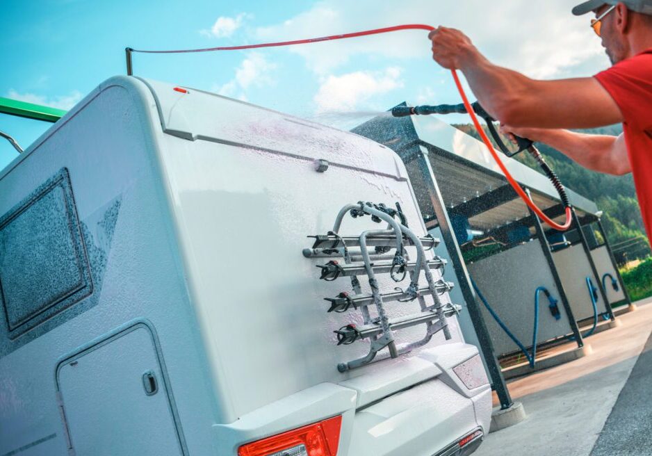 Man washing a white camper van.